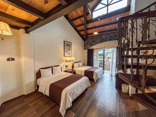 a hotel room with two beds and a staircase at SANTA CECILIA LA MORA HUASCA in Huasca de Ocampo