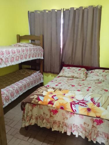 a bedroom with two bunk beds and a window at Casa simples em cunha in Cunha