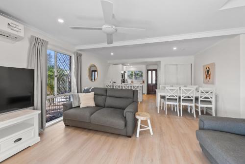 a living room with a couch and a dining room at Family Friendly 2 Bed Flat with Balcony in Mooloolaba