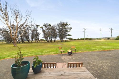 a wooden table with two benches and a field at Oceans Edge Retreat by Tiny Away in Portland