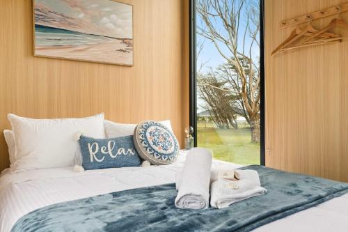a bedroom with a bed with towels and a window at Oceans Edge Retreat by Tiny Away in Portland