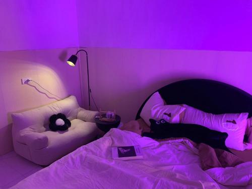 a purple room with two cats laying on a bed at Mây homestay Phan Rang in Bắc Sớn
