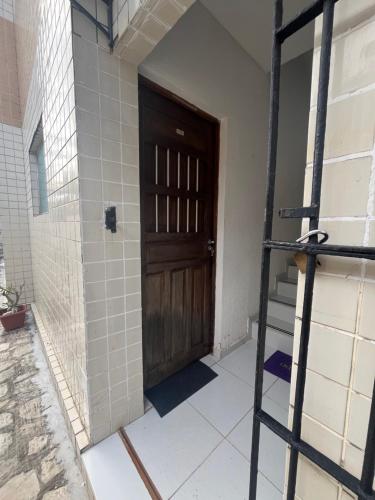 a room with a wooden door and a ladder at Apartamento simples e Familiar conforto e sossego in João Pessoa