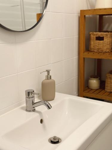 a bathroom sink with a soap dispenser on it at Cantinho da Avó Mifá in Lisbon