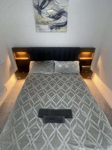 a bed with a black headboard in a bedroom at blackburn home in Blackburn