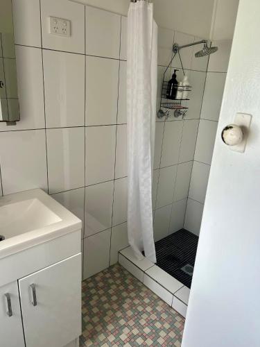 a bathroom with a shower with a shower curtain at Peach Me Beach Shack in Boat Harbour