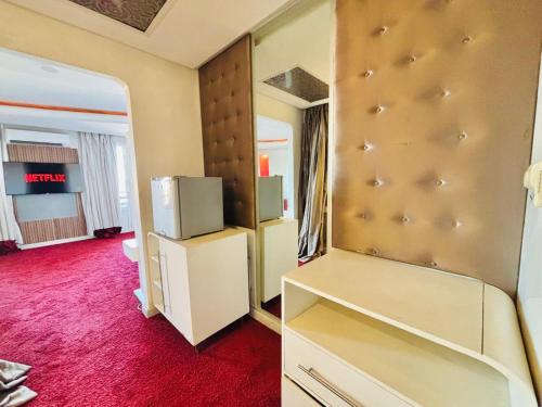 a room with a refrigerator and a tv in it at La Renaissance hôtel Marrakech in Marrakesh