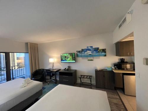 a hotel room with a bed and a kitchen at Penthouse unit at Palms Waikiki in Honolulu