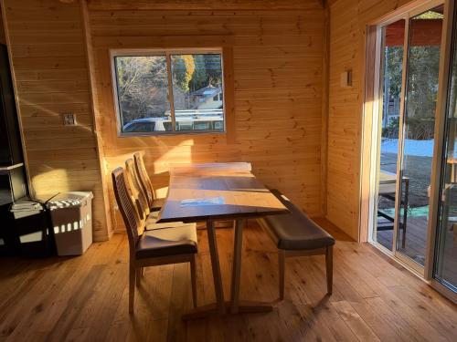 a wooden dining room with a wooden table and chairs at Villa Aso Otohime in Uchinomaki