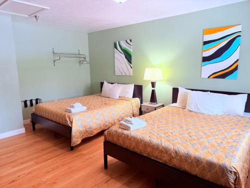 a hotel room with two beds and a lamp at The Kingsley Suites in Kingsley