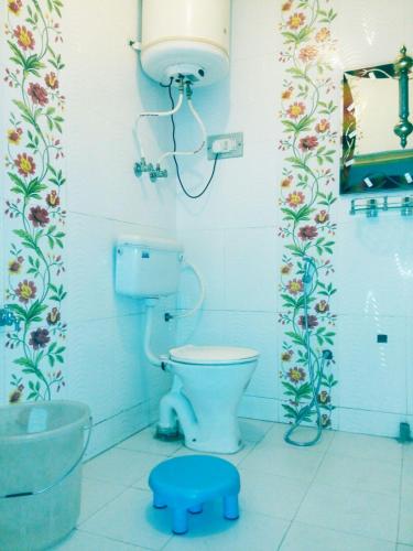 a bathroom with a toilet and a blue stool at Hotel First Kashmir in Srinagar