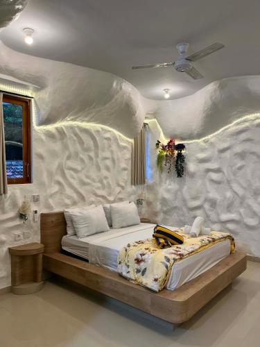 a bedroom with a large bed with a wall at Amed Sea Resort in Amed