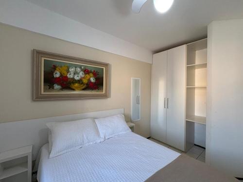 a bedroom with a bed and a painting of flowers at Praia Litorânea in São Luís