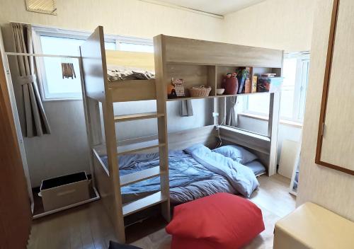 a room with bunk beds with a bed in it at Tasogare Baycity in Hakodate