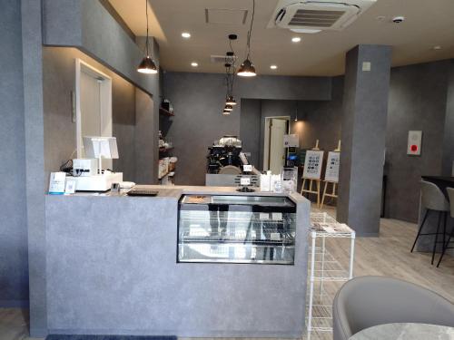 a restaurant with a counter and chairs in a room at HOTEL 萃 the 3rd-雑餉隈駅前-無人ホテル-HOTEL SUI the third-ZASSHO-Unmanned Hotel in Fukuoka