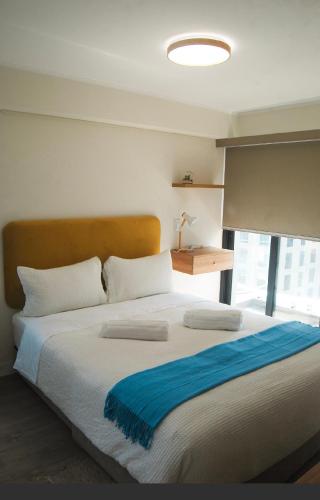 a bedroom with a large bed with a blue blanket on it at Warm & Exclusive 2 BR in San Antonio
