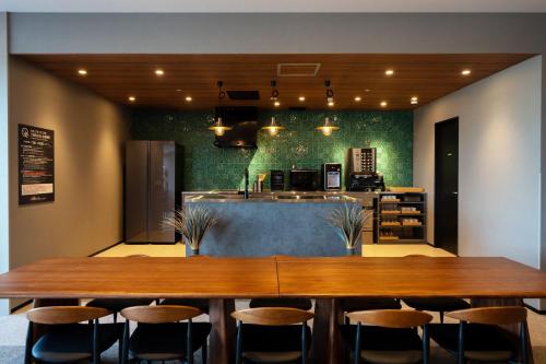 a restaurant with a large wooden table and chairs at Kanohotel and Cabin Chiba Soga in Chiba