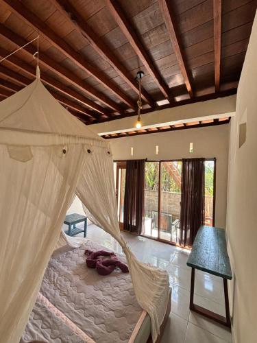 a bedroom with a bed with a mosquito net at THE NYAMO surfschool & stay in Pulukan