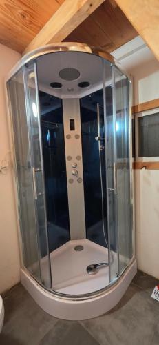 a shower with a glass enclosure in a room at Cabaña Alpina 2 in Coñaripe