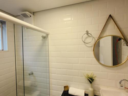 a bathroom with a shower and a mirror at Apê Brooklin -Berrini in São Paulo