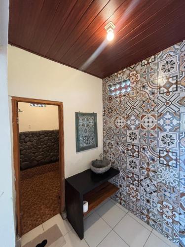 a bathroom with a wall covered in tiles at THE NYAMO surfschool & stay in Pulukan
