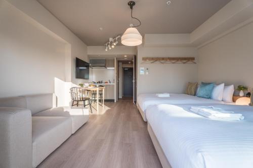 a living room with two beds and a couch at ESLEAD HOTEL Namba East in Osaka