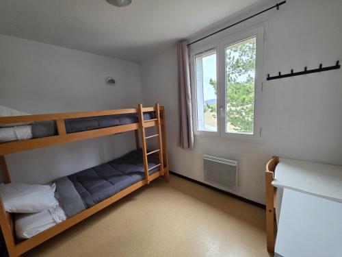 a bedroom with bunk beds and a window at Hostel du Canyon in La Palud-sur-Verdon