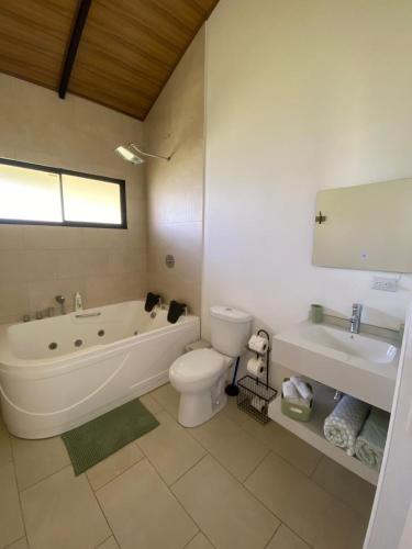 a bathroom with a tub and a toilet and a sink at Cabaña Vistas de Lujo in Fraijanes