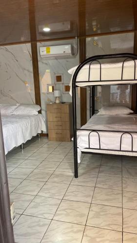 a bedroom with two bunk beds and a tiled floor at Macaws Villa in Ciudad Cortés