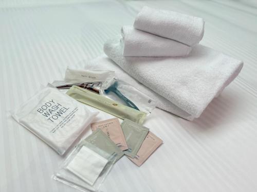 a pile of cosmetics and a towel and a pile of towels at Hotel Keihan Universal Tower in Osaka