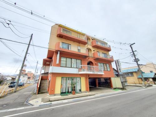 a orange and white building on the side of a street at サムライ シティ イン 信夫屋 in Aizuwakamatsu