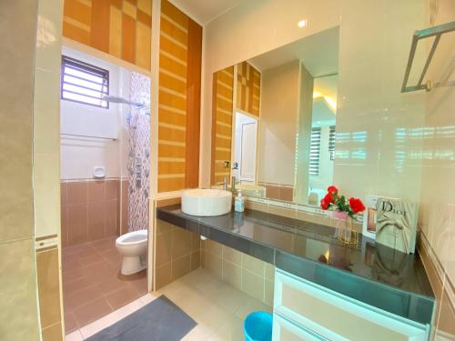 a bathroom with a sink and a toilet and a mirror at Ruma Relaxz by Jeffery Lam Home Management in Malacca