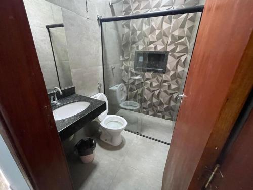a bathroom with a shower and a toilet and a sink at Casa de lazer privativa in Barretos