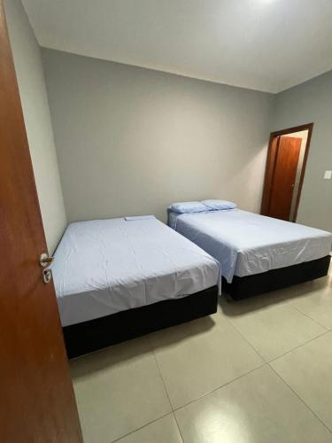 two beds in a small room at Casa de lazer privativa in Barretos