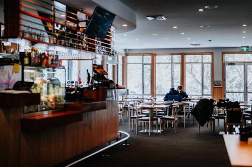 two people sitting at tables in a restaurant at Altitude Apartment 2 in Baw Baw Village