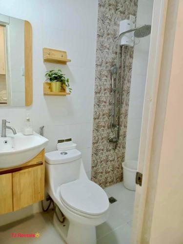 a bathroom with a toilet and a sink and a shower at CASA DOBLE DOSE Condo in Victoria Sports Complex EDSA near GMA Kamuning QC in Manila