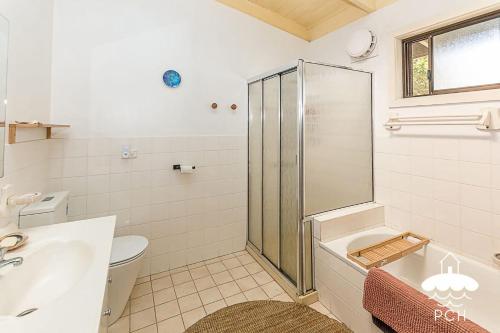 a bathroom with a shower and a sink and a toilet at Dune Cottage Stay 3 Pay 2 Winter Special in Sandy Point
