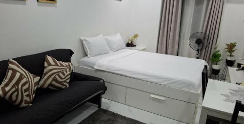 a small bedroom with a bed and a couch at CASA DOBLE DOSE Condo in Victoria Sports Complex EDSA near GMA Kamuning QC in Manila