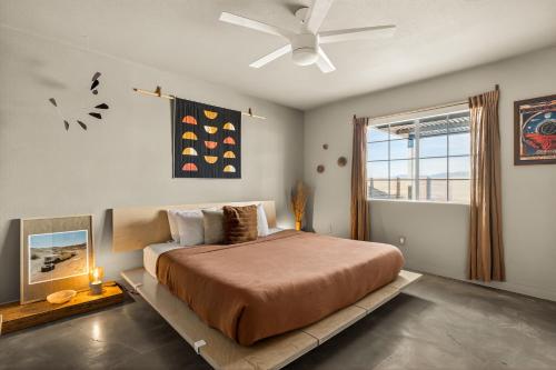 a bedroom with a bed and a ceiling fan at Dark Star - Endless Stars, Cowboy Pool, Spa, Fire pit, BBQ in Twentynine Palms