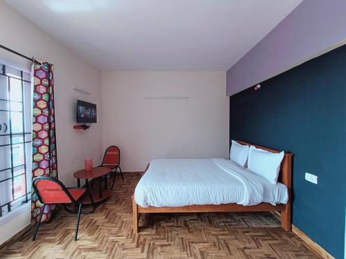 a bedroom with a bed and a table and chairs at Ooty Peak view villa in Ooty