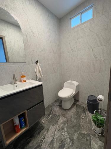 a bathroom with a white toilet and a sink at Alma del Mar in Volcán Chimborazo