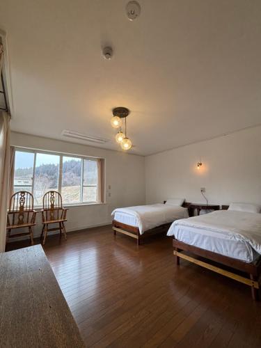 a bedroom with two beds and a large window at koyado kaziya in Ichinoseki