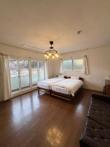 a bedroom with a large bed in a room with windows at koyado kaziya in Ichinoseki
