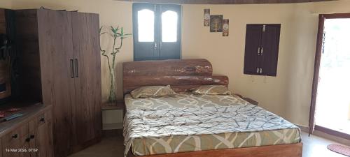 a bedroom with a bed and a dresser at Om Niwas Bhunga in Bhuj