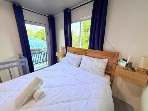 a bedroom with a white bed with a window at Alf's Guesthouse in Panglao Island