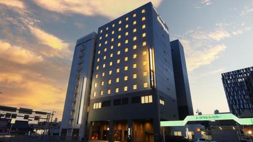 a tall building with lights on in a city at Dormy inn Yokkaichi Natural Hot spring Higoromonoyu in Yokkaichi