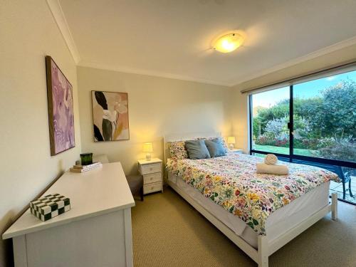 a bedroom with a bed and a large window at Wandju Villa in Geographe
