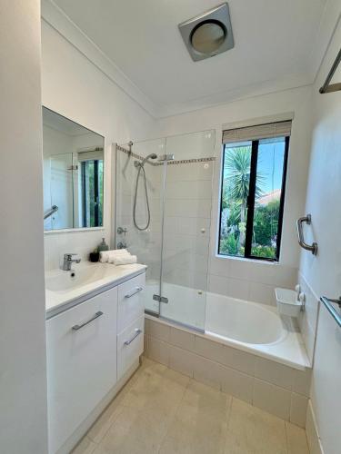 a white bathroom with a tub and a sink at Wandju Villa in Geographe