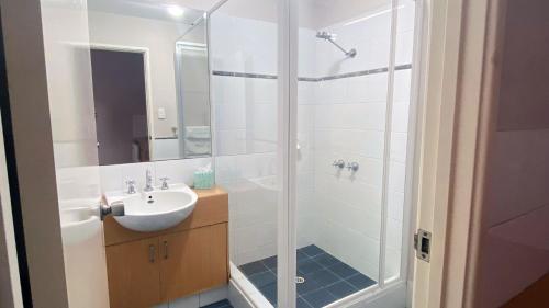 a bathroom with a shower and a sink at Higgins Lane Motel in Margaret River Town