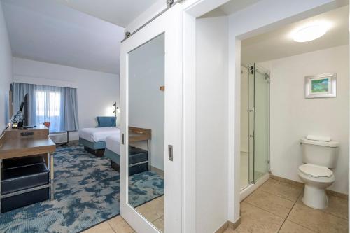 a bathroom with a toilet and a bed and a sink at Hampton Inn by Hilton Spring Hill in Timber Pines